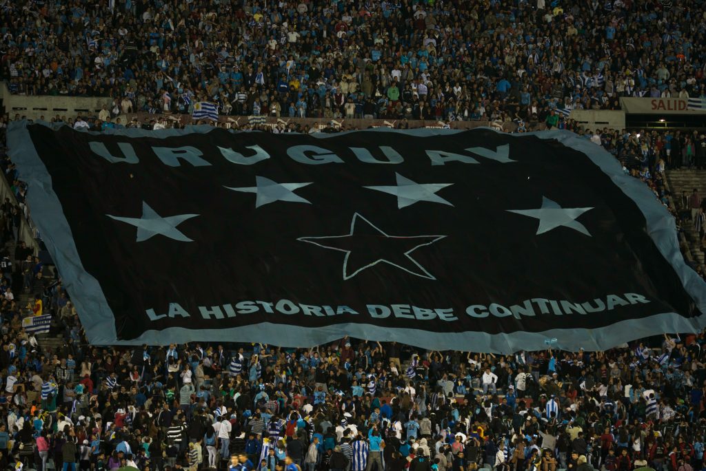 bandera de Uruguay desplegada por hinchas en el estadio centenario tradiciones uruguayas