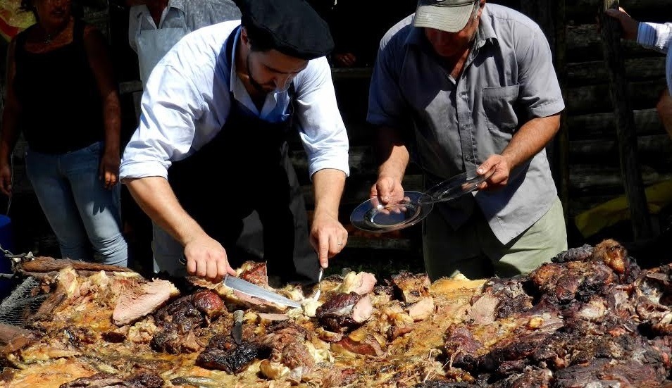 asador sirviendo asado con cuero desde una parrilla al aire libre tradiciones uruguayas
