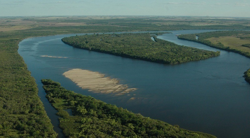 Imagen aérea de un recodo del Río Negro con una isla sobre la que hay mucha vegetación