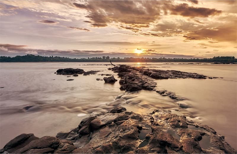 Imagen de una formación rocosa sobre el río al atardecer