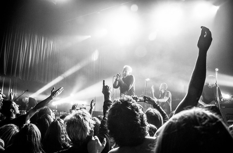 Imagen en Blanco y Negro de Gabriel Peluffo cantando sobre un escenario, con un público numeroso frente a él