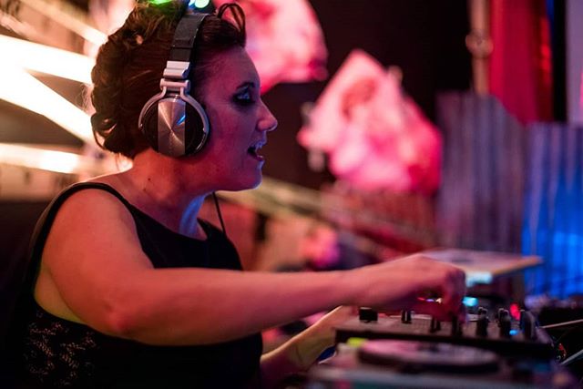 Imagen de Paola Dalto tocando sobre una bandeja de discos en una fiesta electrónica