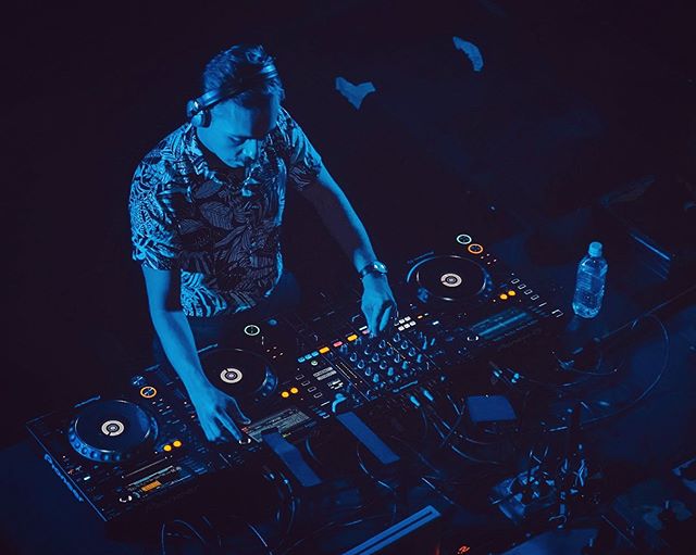 Imagen de un hombre frente a una bandeja tocando música electrónica