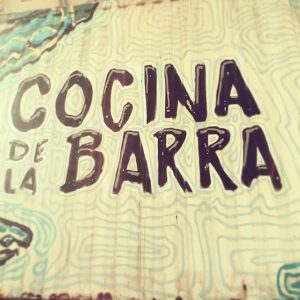 Imagen de un cartel amarillo y verde que dice, en letras negras, "Cocina de la Barra"