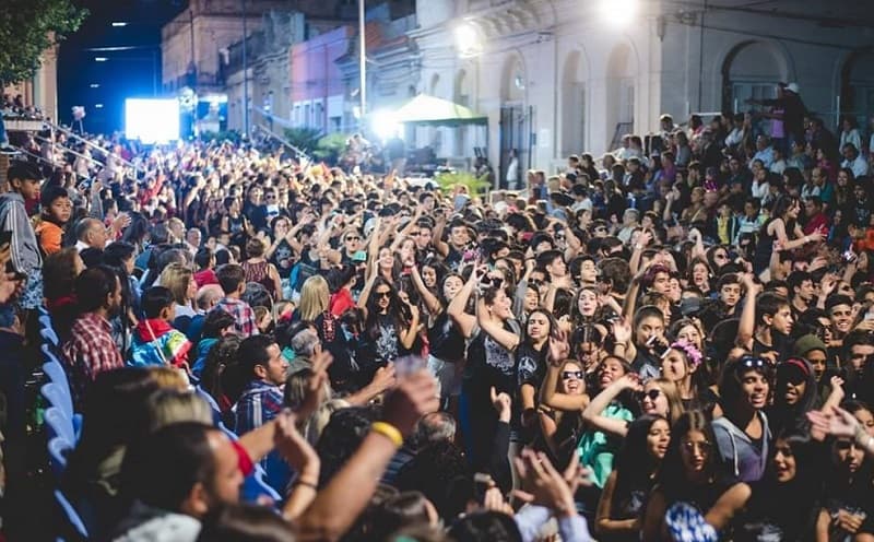 Una muchedumbre desfila bailando por la calle principal de la ciudad de Melo