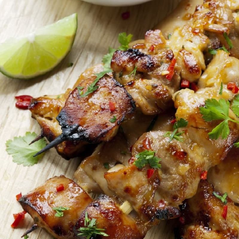 Imagen de una brochet con carne de pescado; acompañado de una rodaja de lima