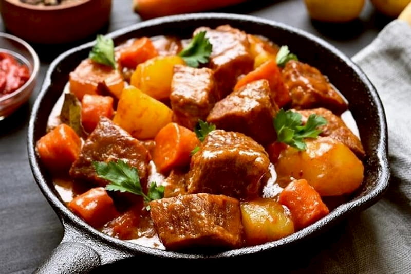 Un plato con cubos de carne, y verduras.