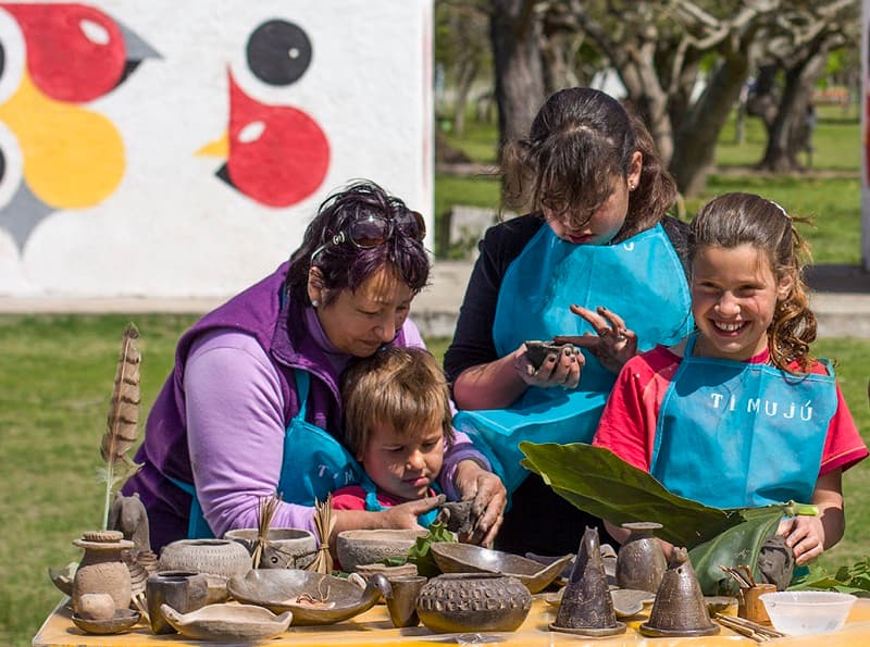 Una mujer le enseña alfarería a varias niñas